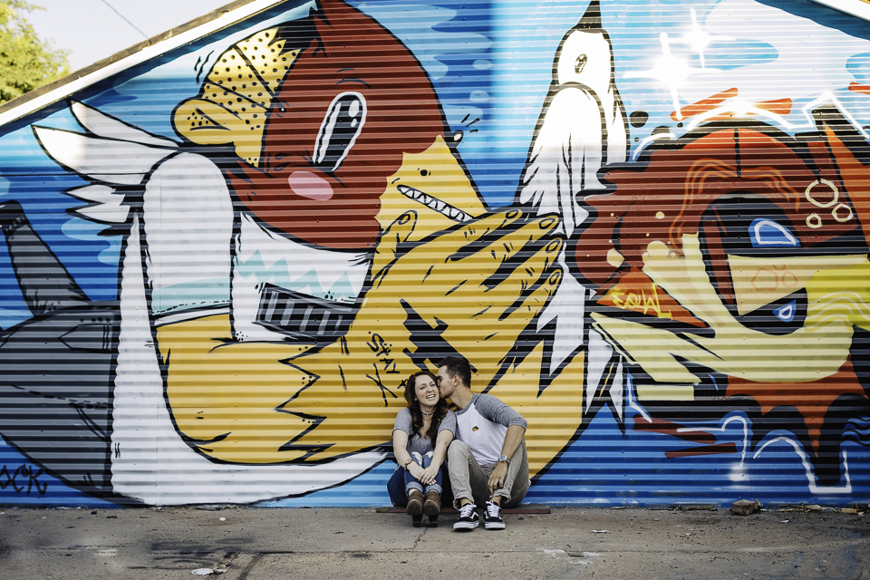 Couple sitting in front of a graffiti wall