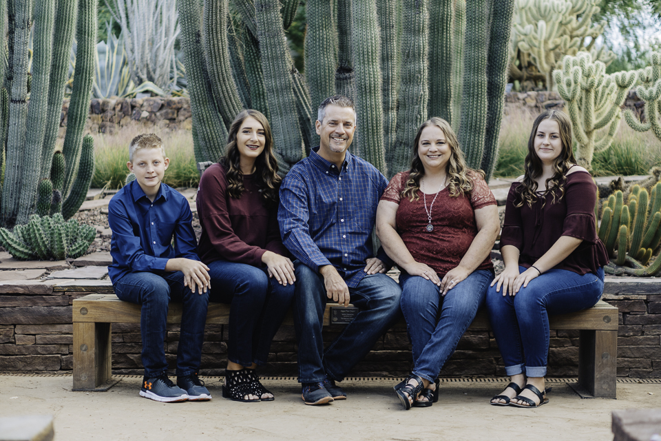 Family posing in front of a cactus.