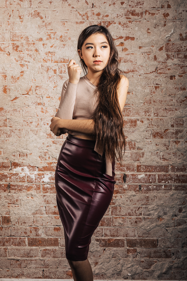 Senior model posing in a leather dress.