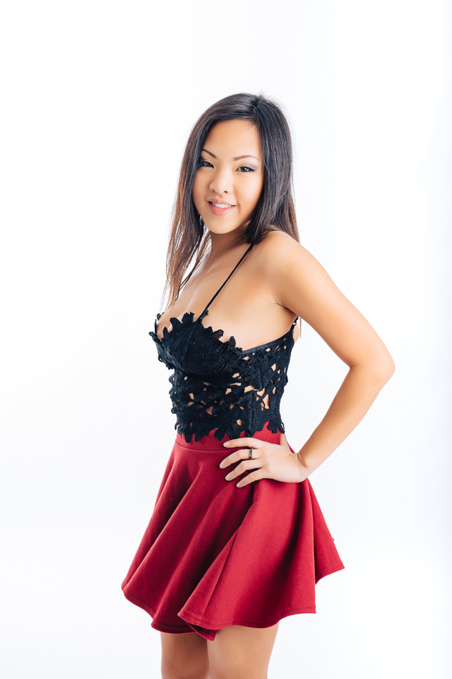 Model posing with a black top and red skirt.