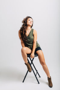 Model posing on a black stool.